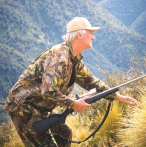A hunter, advancing crouched with gun in hand